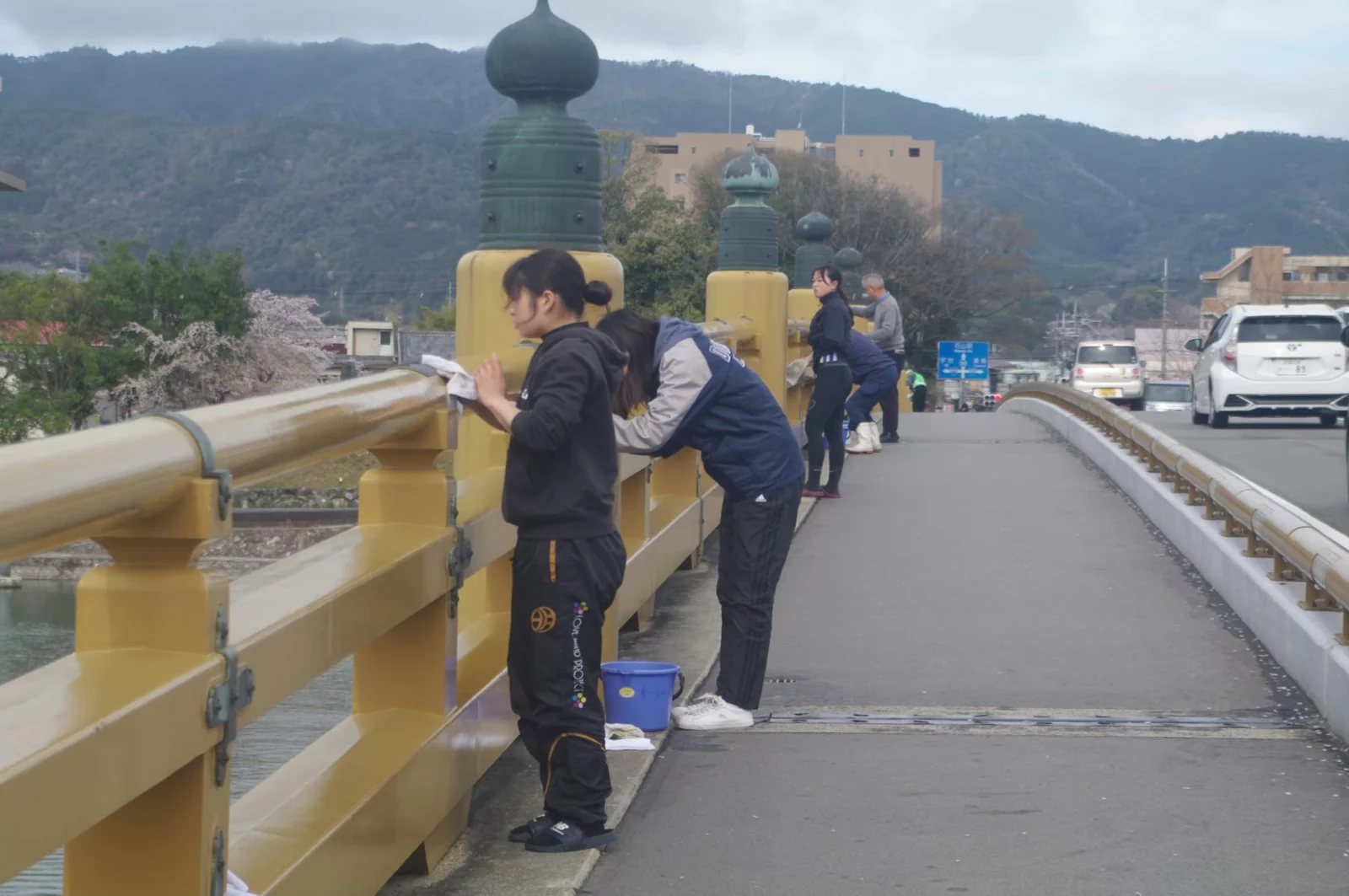 瀬田の唐橋の欄干を清掃する地域の人たち。